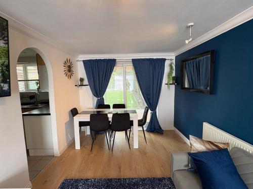 a living room with a table and blue walls at Modern and Spacious 3 Bed retreat - Bracknell in Easthampstead