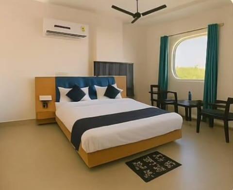 a bedroom with a large bed and a window at Hotel Neel Regency in Kurukshetra
