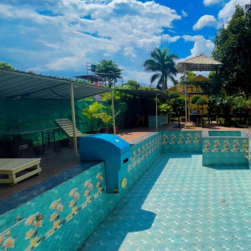 a resort with a swimming pool with a blue object at Amritvan Farms in Noida
