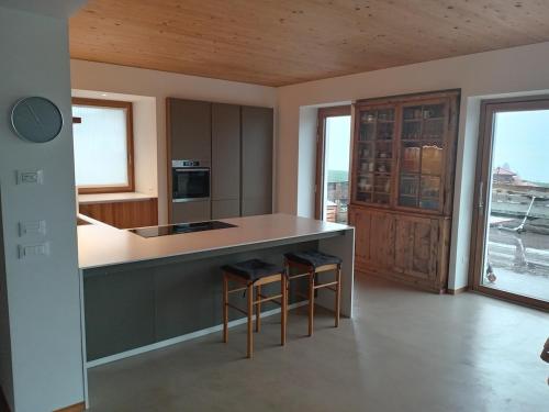 Una cocina con encimera y taburetes en una habitación. en Relaxing accommodation and family, en Flavon