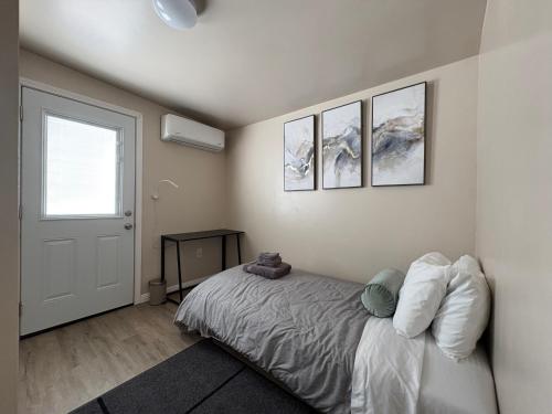 a bedroom with a bed with three pictures on the wall at Comfortable Place, Great Location, Fiber Wifi, and Free Parking in Hayward