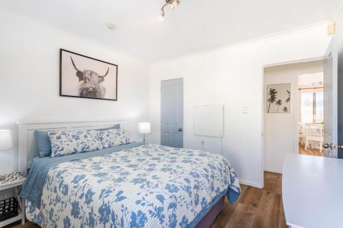 a bedroom with a bed with a blue and white bedspread at Matahari Apartments and Villas in Upper Hutt