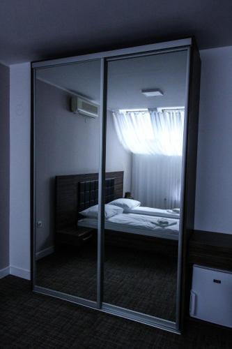 a mirror in a room with a bedroom with a bed at Hotel Story in Sarajevo