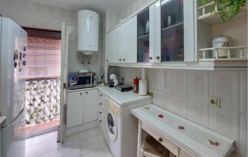 a kitchen with white cabinets and a window at Casa Del Arco in Ronda