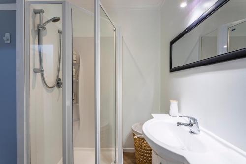 a bathroom with a shower and a sink at Matahari Apartments and Villas in Upper Hutt