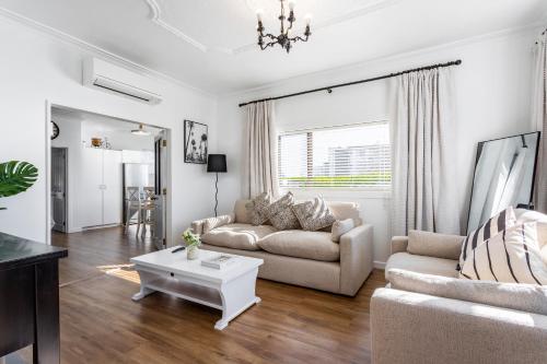 a living room with a couch and a table at Matahari Apartments and Villas in Upper Hutt