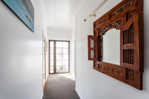 a mirror on the wall of a room with a hallway at Matahari Apartments and Villas in Upper Hutt