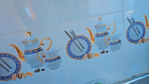 Cozy Breeze Apartment في مومباسا: رف به أكواب وأواني زرقاء اللون