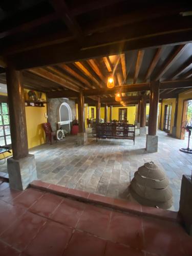 a large room with a stone floor and wooden ceiling at Xóm Cảng homestay-Thac Ba lake in Yên Bái