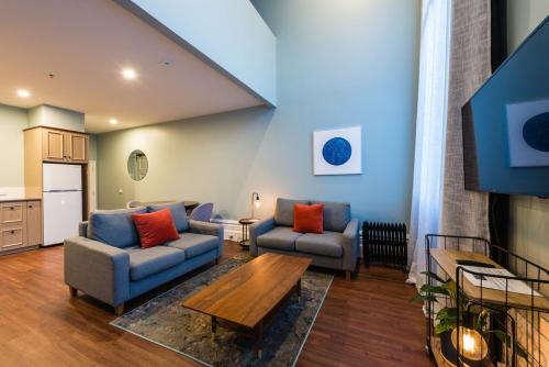 a living room with two couches and a table at 1 Bedroom Apartment Pool Car Park Cathedral Square in Christchurch
