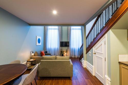 a living room with a couch and a table at 1 Bedroom Apartment Pool Car Park Cathedral Square in Christchurch