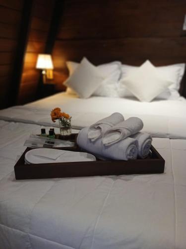 two beds with a tray of towels on a bed at Chena Hut Habarana in Habarana