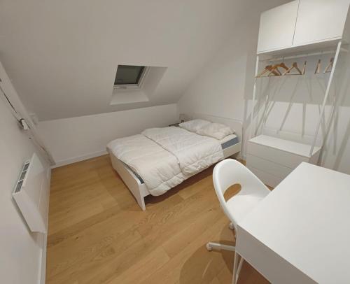 a small white room with a bed and a chair at Maison Loire & Cé'rénité in Les Ponts-de-Cé