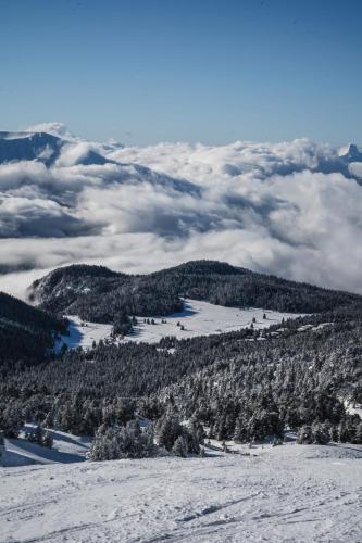 a view from the top of a snowy mountain with clouds at Chamrousse - Résidence La Grive in Chamrousse