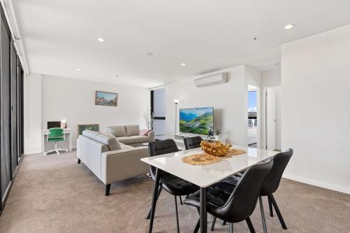 a dining room and living room with a table and chairs at 3BR 3BA Next to Mall & Govt Hub with Pool and Gym in Belconnen
