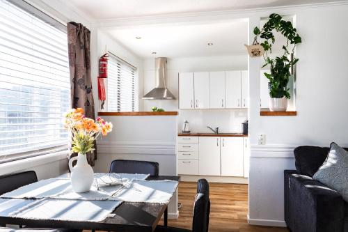 a living room with a table and a kitchen at Matahari Apartments and Villas in Upper Hutt