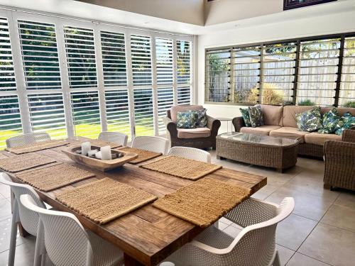 クーラムビーチにあるCinnamon Beach houseの木製のテーブルと椅子のあるリビングルーム