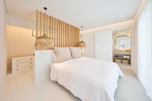 a white bedroom with a white bed and a mirror at Tropical Garden on City Center in Funchal