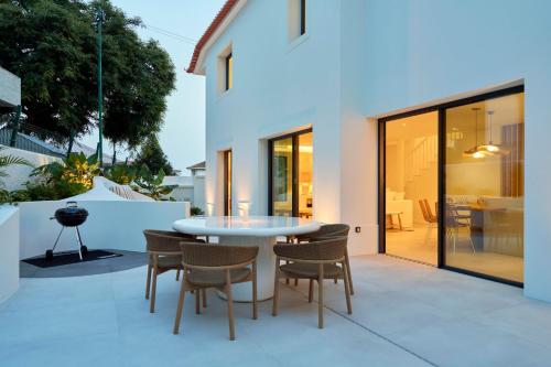 a patio with a white table and chairs at Tropical Garden on City Center in Funchal