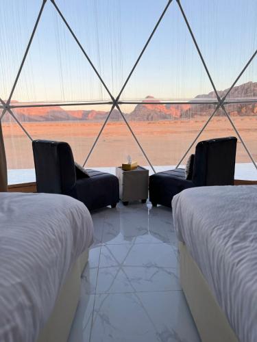 una stanza con due letti e vista sul deserto di Bubble Camp Wadi Rum a Wadi Rum