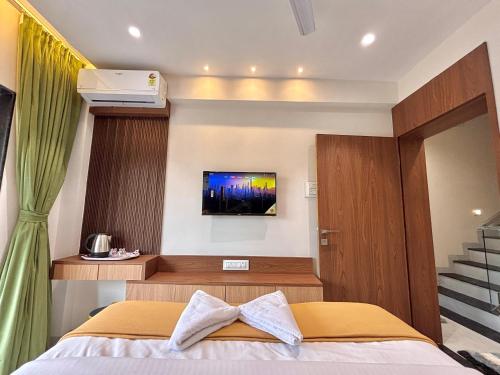 a bedroom with a bed with a television on the wall at Nivaant - by Marathi Zatka in Lonavala