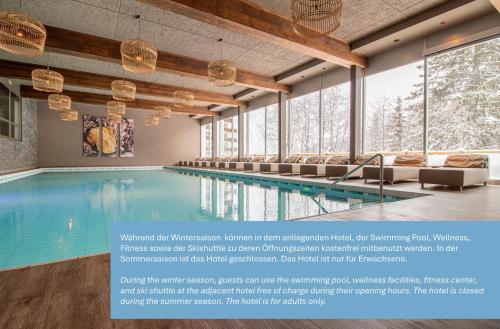 una piscina en un edificio con ventanas en Rothornblick 32 by Arosa Holiday, en Arosa