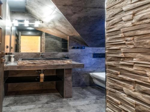 a bathroom with a large sink and a stone wall at Villa in Nowy Targ with Mountain Views & Pool in Nowy Targ