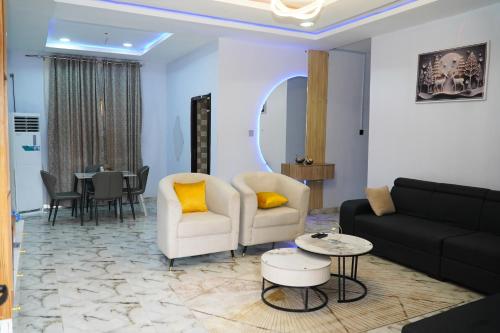 ein Wohnzimmer mit einer Couch und Stühlen und einem Tisch in der Unterkunft Serenity place in Ilorin