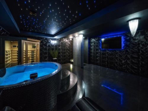 a jacuzzi tub in a room with blue lights at Villa in Nowy Targ with Mountain Views & Pool in Nowy Targ