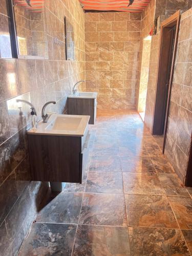 un bagno con lavandino e pavimento piastrellato di Bubble Camp Wadi Rum a Wadi Rum