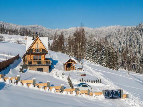 a log cabin in the snow with snow covered trees at Villa in Nowy Targ with Mountain Views & Pool in Nowy Targ