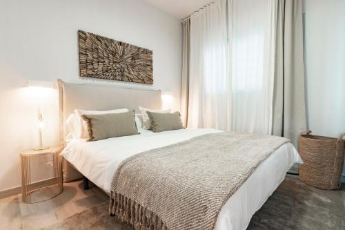 a bedroom with a large white bed and a window at Mara's Apartments Higuerón - Azzurro Med Two Collection - Seaviews in Fuengirola