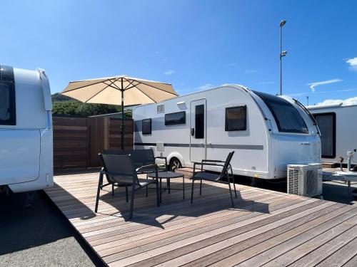 a patio with a table and chairs and an rv at Aquaignis Awaji Island TRAILER PARK in Awaji