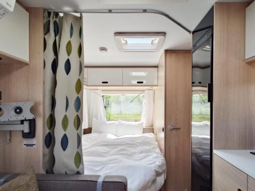 a bedroom in an rv with a bed and a window at Aquaignis Awaji Island TRAILER PARK in Awaji