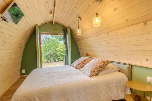 a bedroom with a bed in a room with a window at Chambre d'Hôtes La Guignette in Saint-Cybranet