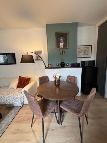 a living room with a table and chairs and a couch at L'inattendue in Pierrefonds