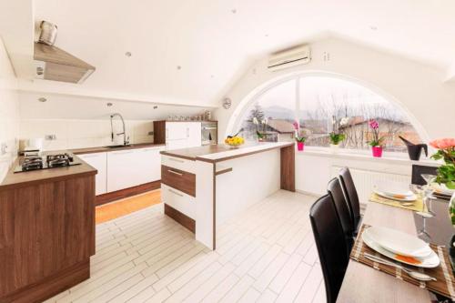 a kitchen with an arched window and a table and chairs at Apartment Mountain Sunrise in Škofja Loka