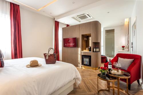 a hotel room with a bed and a red chair at La Seine Hotel in Vientiane