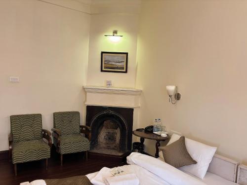 a living room with a couch and a fireplace at Pineridge Hotel at Mall Road in Darjeeling
