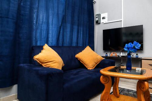 a blue couch with yellow pillows in a living room at Royal Blue Family Haven in Rustenburg