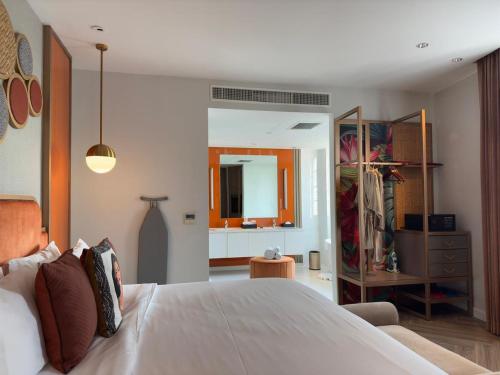 a bedroom with a large white bed and a mirror at La Seine Hotel in Vientiane