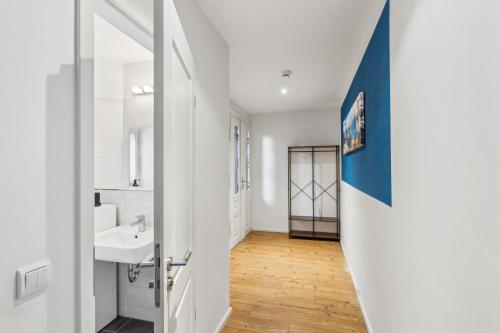 une salle de bain blanche avec un lavabo et un miroir dans l'établissement Erholsame Wohnung mit Balkon und Einbauküche im Herzen Leipzigs, à Leipzig