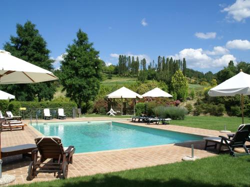 a swimming pool with chairs and umbrellas at Holiday Home in Montone with Pool & Terrace in Montone