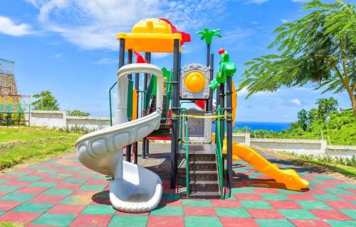 a playground with a slide on a tiled ground at Summerbreeze at Pyramid Point in Breadnut Hill