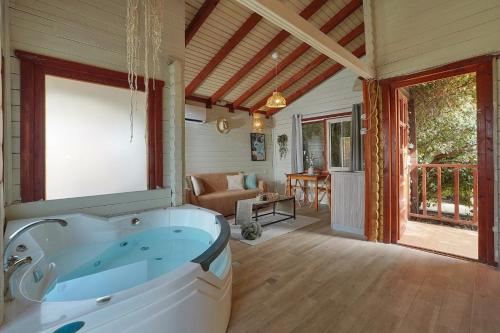 a large bathroom with a tub in a room at בקתות לואיז in Had Nes