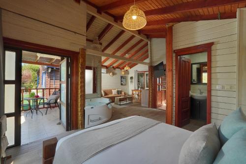 a bedroom with a large bed and a bathroom at בקתות לואיז in Had Nes