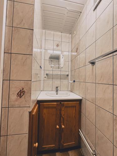 a bathroom with a sink in a tiled wall at Thak in Francorchamps