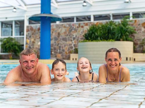 a group of people swimming in a swimming pool at Vigsø Holiday Center in Hanstholm