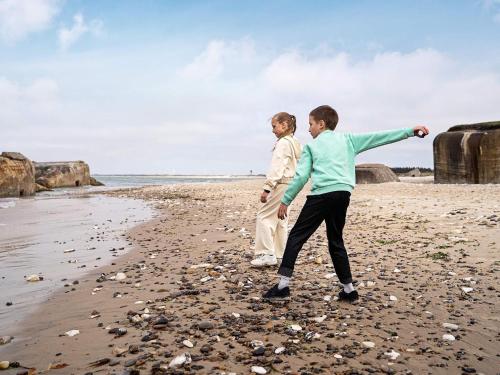 two people playing with a frisbee on the beach at Vigsø Holiday Center in Hanstholm