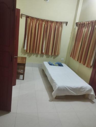 mayapurにあるKrishna Divine 2 Bedroom Homeのベッドと2つの窓がある寝室